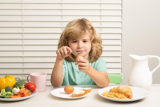 Criança comendo ovo criança menino comendo alimentos orgânicos saudáveis vegetais saudáveis com vitaminas adequadas crianças