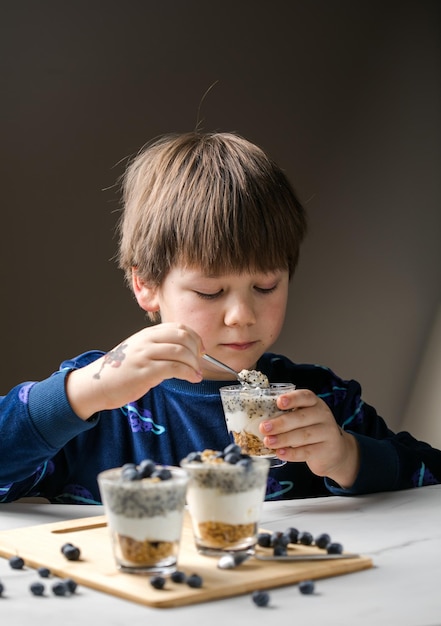 Criança comendo parfait Criança come alimentos orgânicos Legumes saudáveis com vitaminas Conceito adequado de nutrição infantil