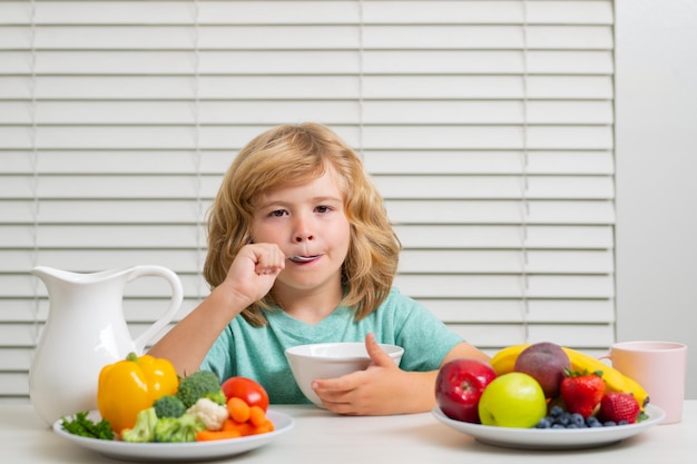 Criança comendo refeição nutrição saudável para crianças menino bonito lambe colher gosta de comer no café da manhã