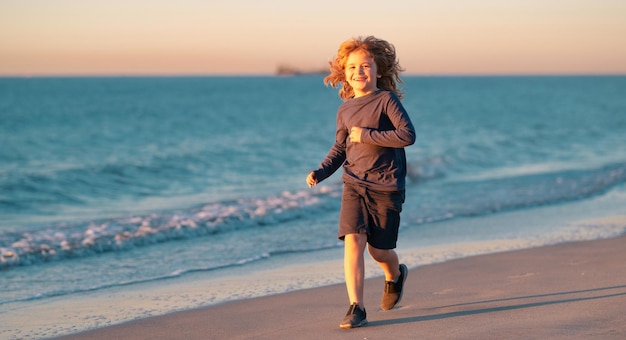 Criança corre à beira-mar crianças correndo nas férias de verão na praia garoto feliz menino brincando na praia criança feliz