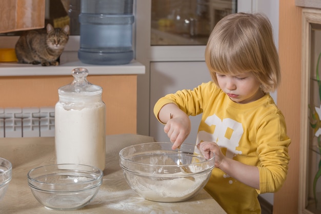 Criança cozinhando na cozinha.