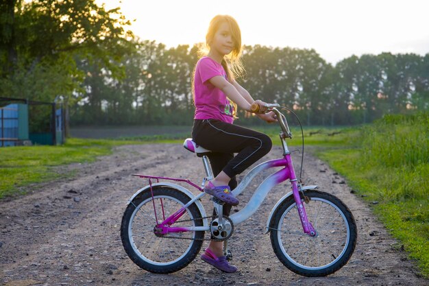 Criança de bicicleta ao pôr do sol