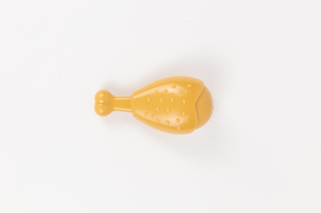 Foto criança de brinquedo de plástico de perna de galinha em um fundo branco