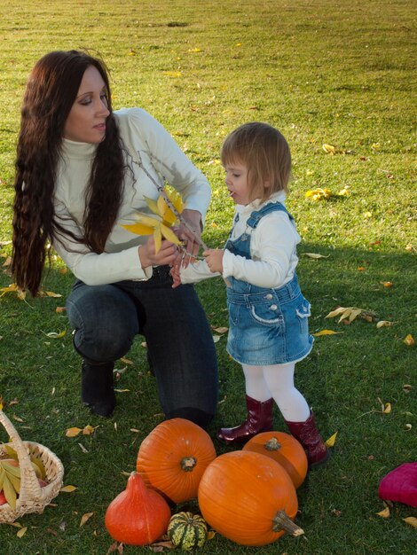 Criança de menina com a mãe no parque outono.