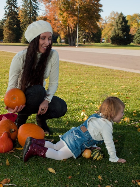 Criança de menina com a mãe no parque outono.