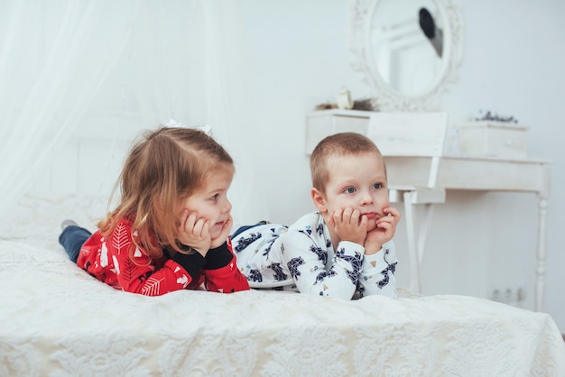 Criança de pijama macio e quente brincando na cama