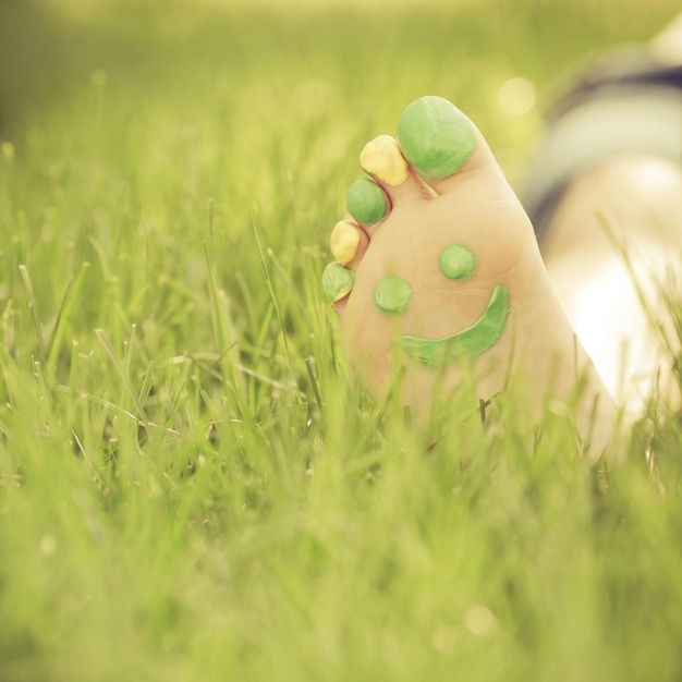 Criança deitada na grama verde. Garoto se divertindo ao ar livre no parque primavera