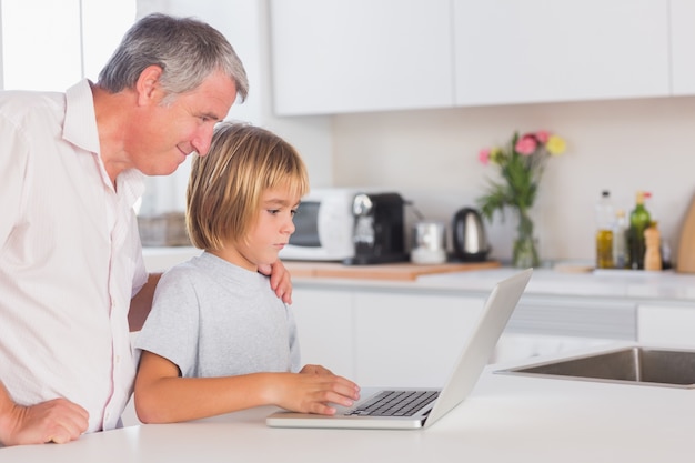 Criança e avô olhando laptop