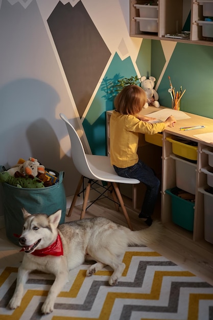 Foto criança e cachorro de estimação juntos no quarto das crianças