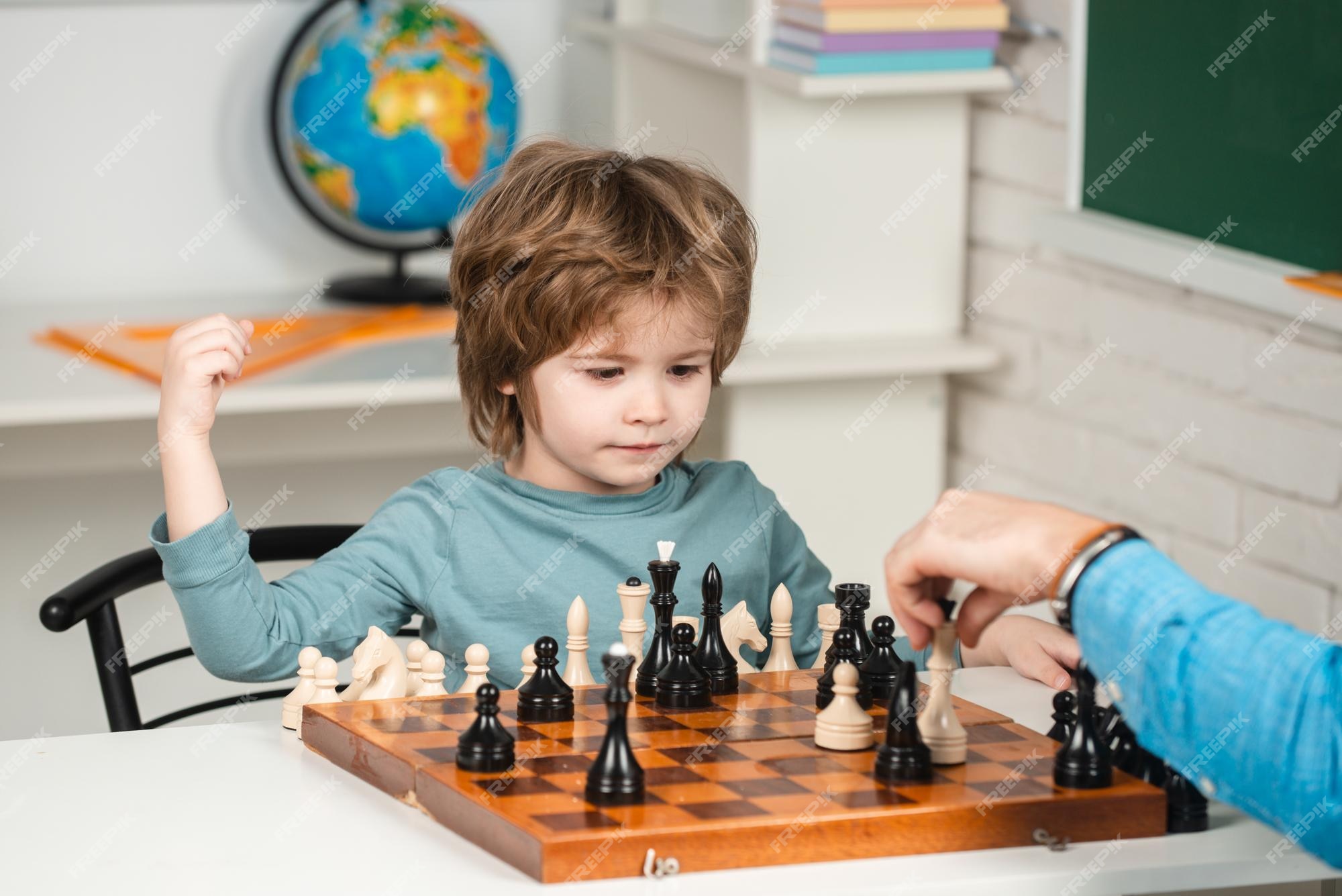 conceito de educação de xadrez online. menino sentado à mesa com