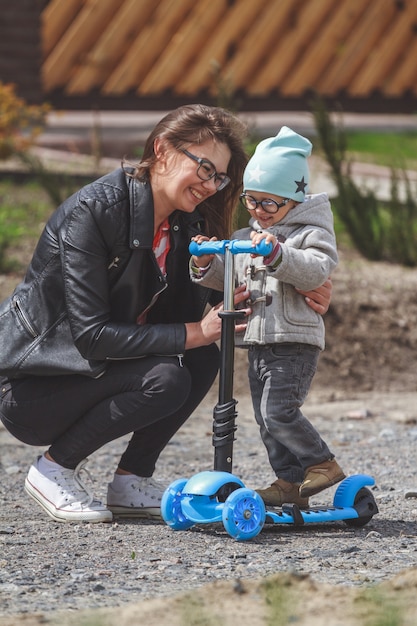 Criança e mãe brincam ao ar livre com scooter