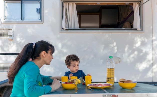 Criança e mãe fazendo piquenique ao lado do motor home