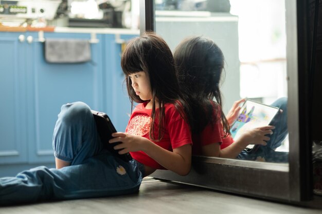Criança é viciada em tablet garotinha jogando smartphone criança usa telefone assistindo desenho animado
