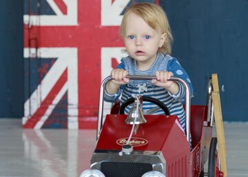 O conceito de infância e as pessoas é uma menina feliz de três anos  brincando com um carro de brinquedo em casa . fotos, imagens de © Shangarey  #274892646