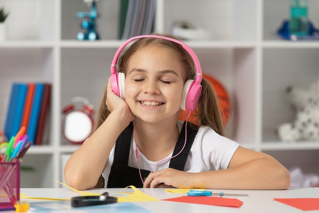 Criança em fones de ouvido modernos. Educação online. de volta à escola. menina adolescente feliz em fones de ouvido. amante da música. escutar musica. acessório de dispositivo de fone de ouvido sem fio. nova tecnologia. desenvolvimento infantil.