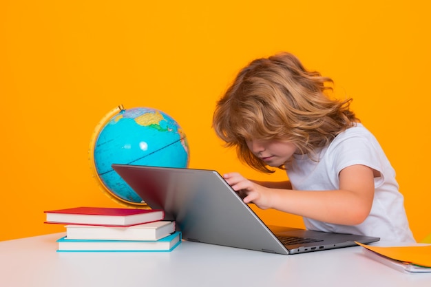 Criança em idade escolar usando computador portátil Criança em idade escolar de 78 anos com livro voltar para a escola Pequeno aluno Conceito de educação