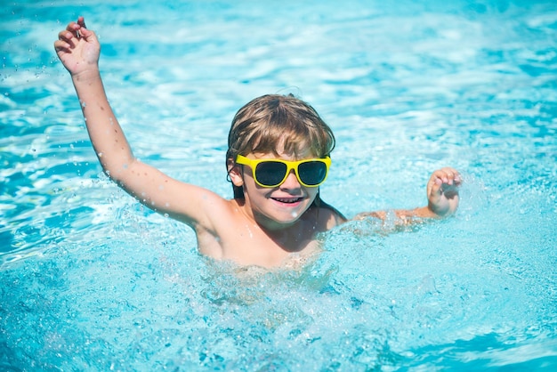 Criança em óculos de sol na praia retrato de criança bonita se divertindo na piscina