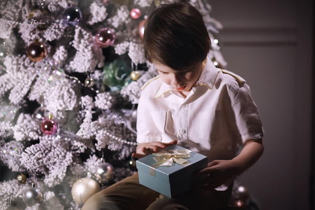 Criança em roupas inteligentes em frente à árvore de Natal Véspera de Ano Novo Esperando o ano novo