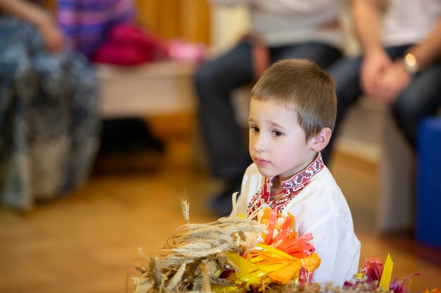 Criança em traje étnico eslavo Um menino em uma camisa bordada