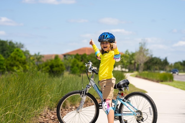 Criança em um menino de bicicleta em um capacete andando de bicicleta garotinho caucasiano bonitinho no capacete de segurança andando de bicicleta