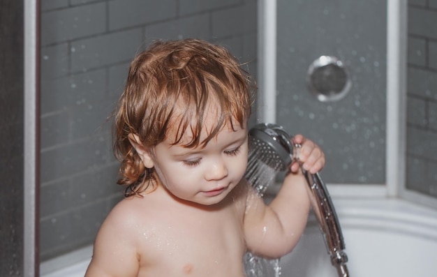 Criança em uma banheira A criança bebê está lavando o cabelo no banho