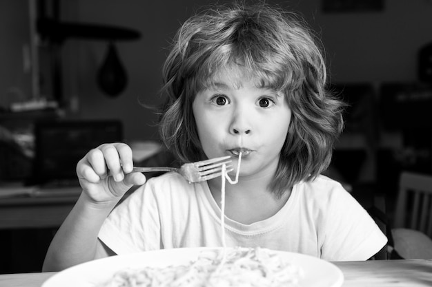 Criança engraçada comendo macarrão espaguete crianças enfrentam retrato de menino