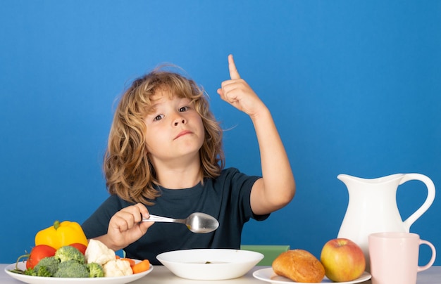 Criança engraçada comendo sopa criança pequena comendo uma sopa menino comendo sopa no jantar