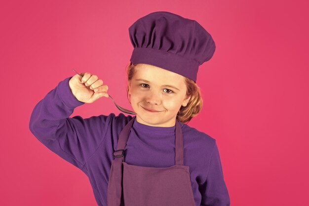 Criança engraçada cozinheira cozinheira com colher criança cozinheira estúdio retrato crianças cozinhando menino com avental