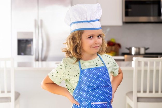 Criança engraçada fica na mesa da cozinha se diverte fazendo padaria preparando comida em casa kithen