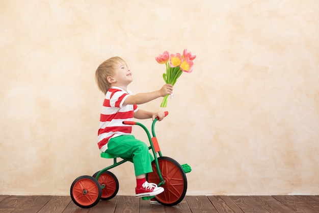 Criança engraçada segurando um buquê de flores.