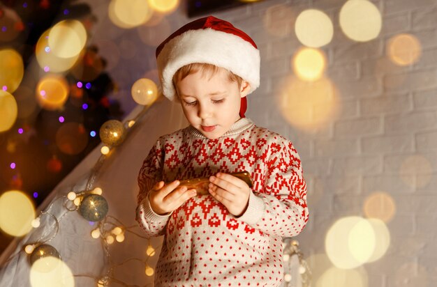 Criança engraçada usando o celular para fazer uma videochamada para cumprimentar seus amigos