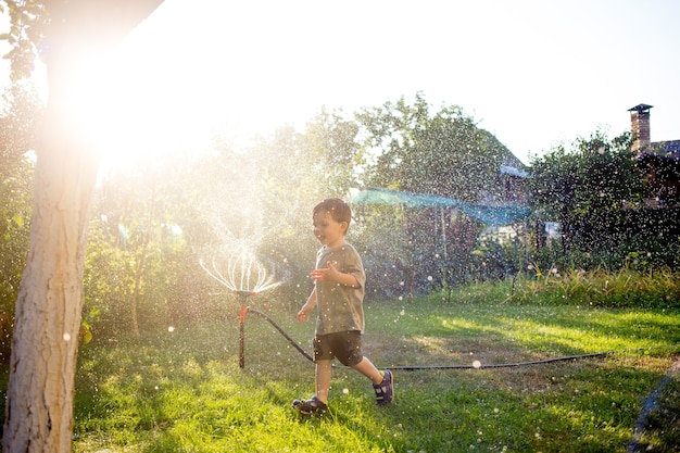 Criança enquanto brincam com a cana-de-água em um jardim. Conceito: Liberdade, felicidade, tempo livre.