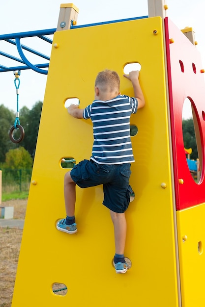 Criança escalando em uma parede no playground da atração.