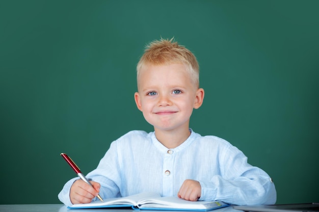 Criança escrevendo em classe Estudante de escola aprendendo em classe estuda língua inglesa na escola