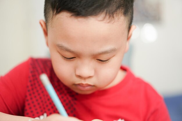 Criança escrevendo no caderno para escola