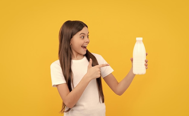 Foto criança espantada aponta o dedo no produto de bebidas lácteas adolescente vai beber leite