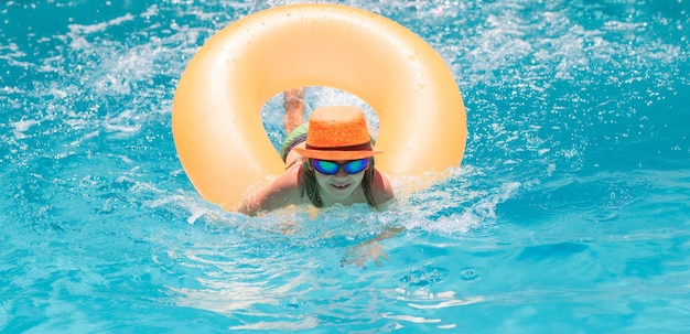 Criança espirrando na piscina Atividade esportiva aquática nas férias de verão com crianças Brinquedos aquáticos para crianças