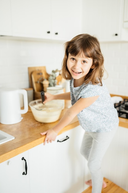 Criança fazendo panquecas para o café da manhã Vida doméstica de pessoas reais