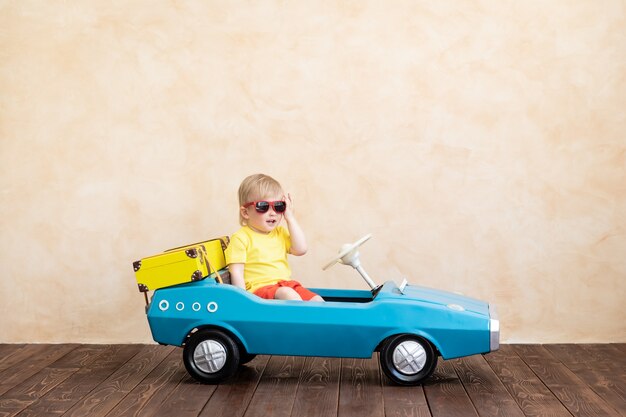 Foto criança feliz andando de carro antigo de brinquedo