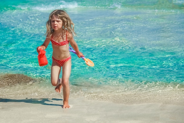 Criança feliz brincando à beira-mar ao ar livre