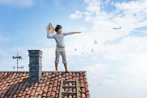 Criança feliz brincando com avião de papel. Mídia mista