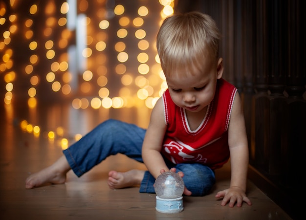 Foto criança feliz brincando com esfera de natal