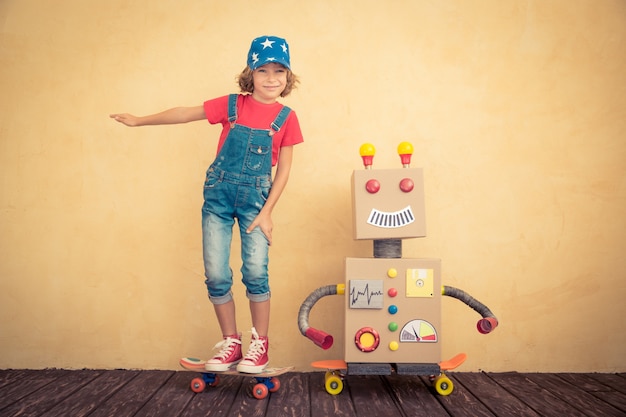 Criança feliz brincando com o robô de brinquedo em casa. Retro tonificado