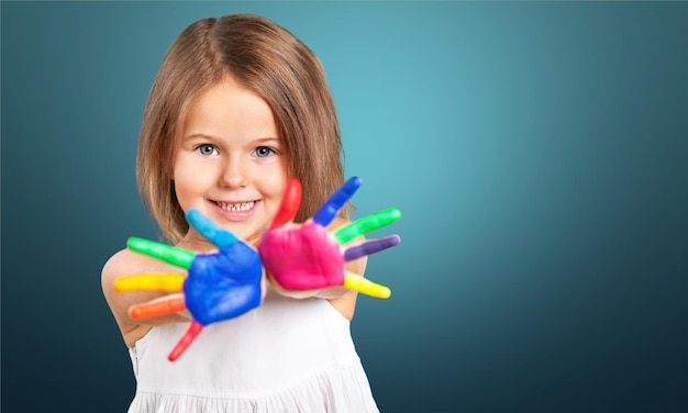 Criança feliz brincando com tintas nos dedos.