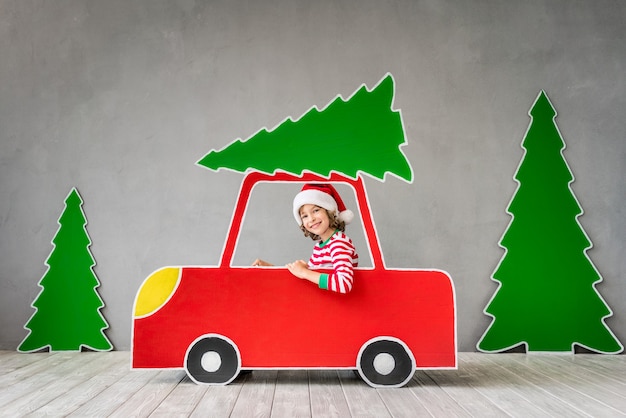 Criança feliz brincando em casa. Garoto engraçado na véspera de natal