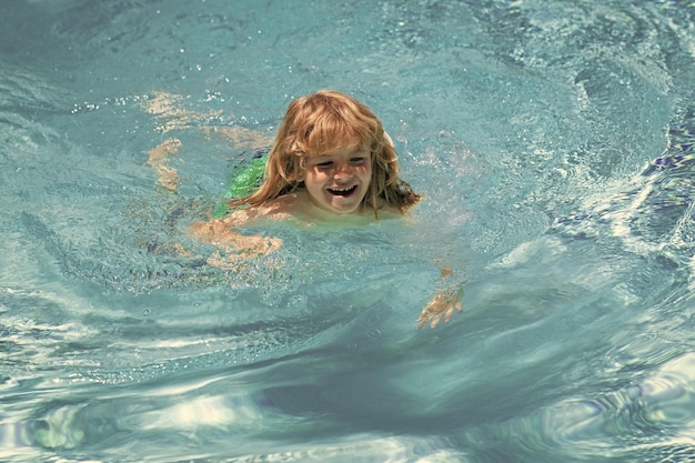 Criança feliz brincando na piscina Férias de verão para crianças Garotinho relaxando em uma piscina se divertindo durante as férias de verão