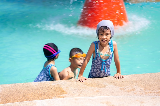 Criança feliz brincando na piscina no dia