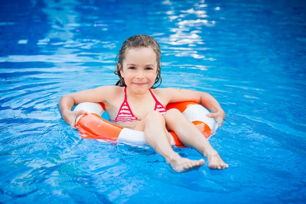 Criança feliz brincando na piscina