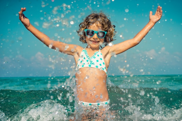 criança feliz brincando no mar