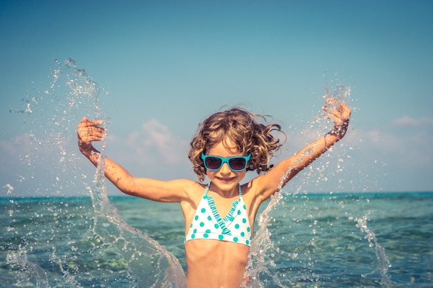 Criança feliz brincando no mar